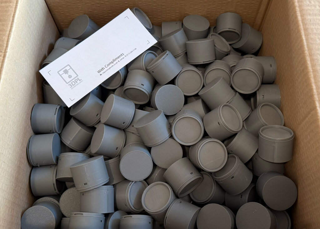 Industrial 3D printed miniature paint tins prepared for small-batch promotional production